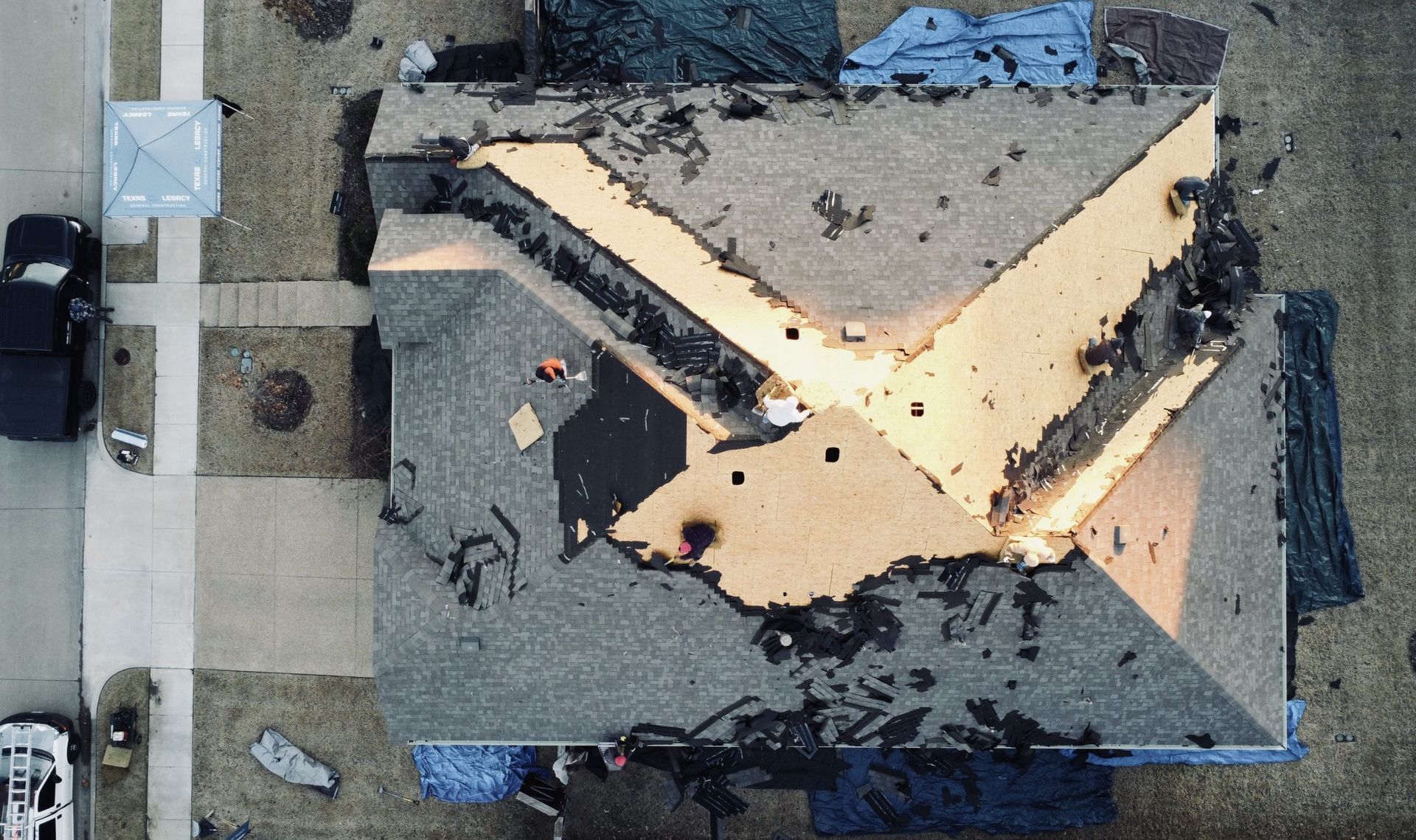 An aerial view of a house with a roof that is being repaired.