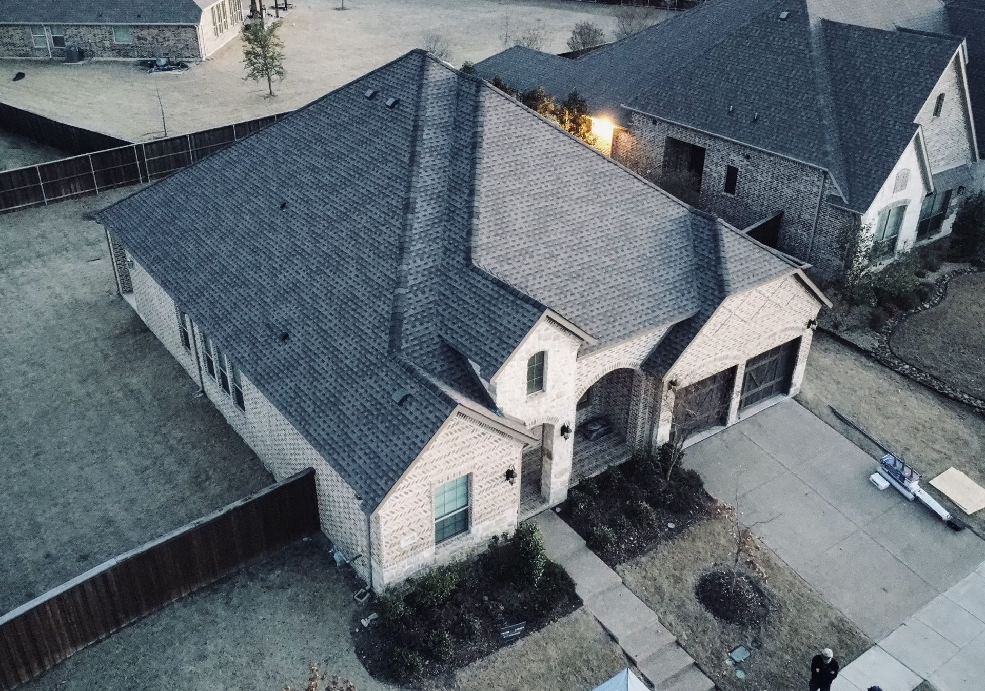 An aerial view of a house with a black roof.