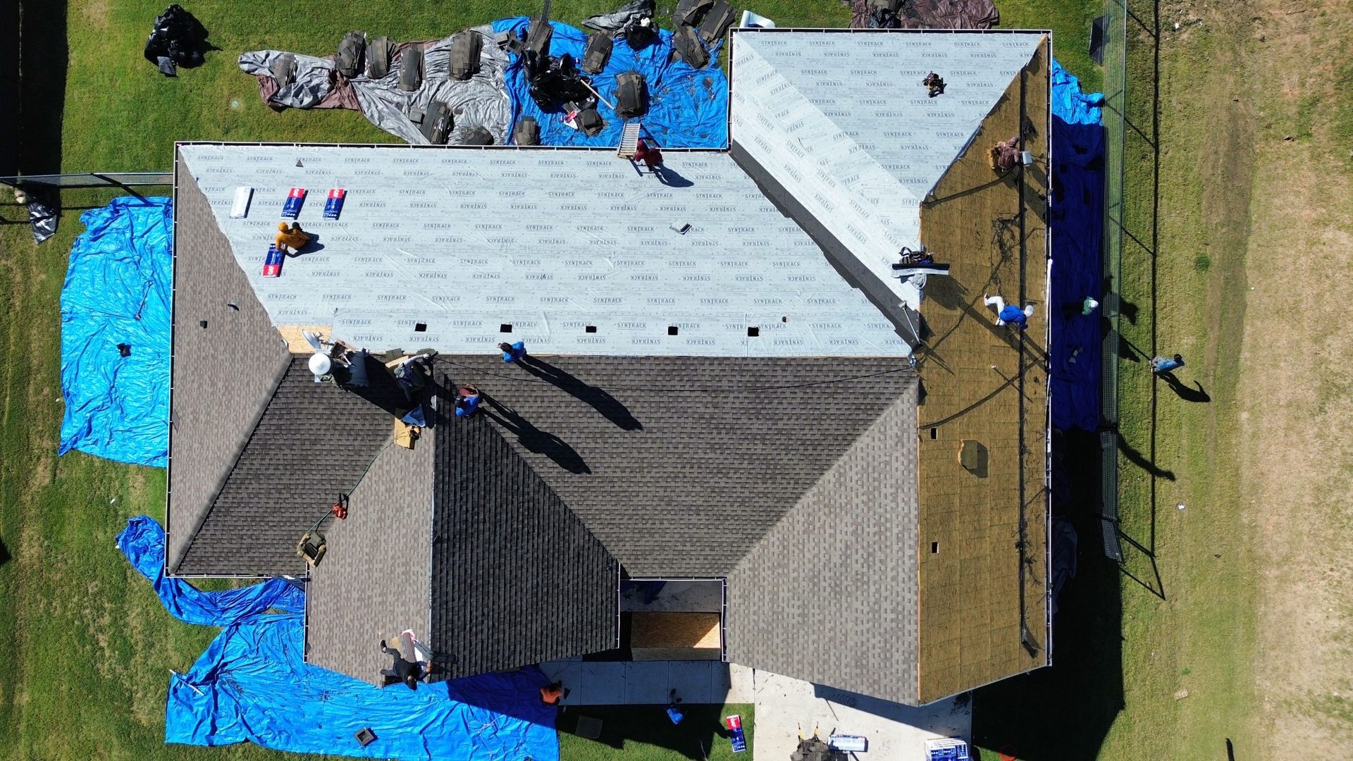 An aerial view of a house being remodeled with a roof being installed.