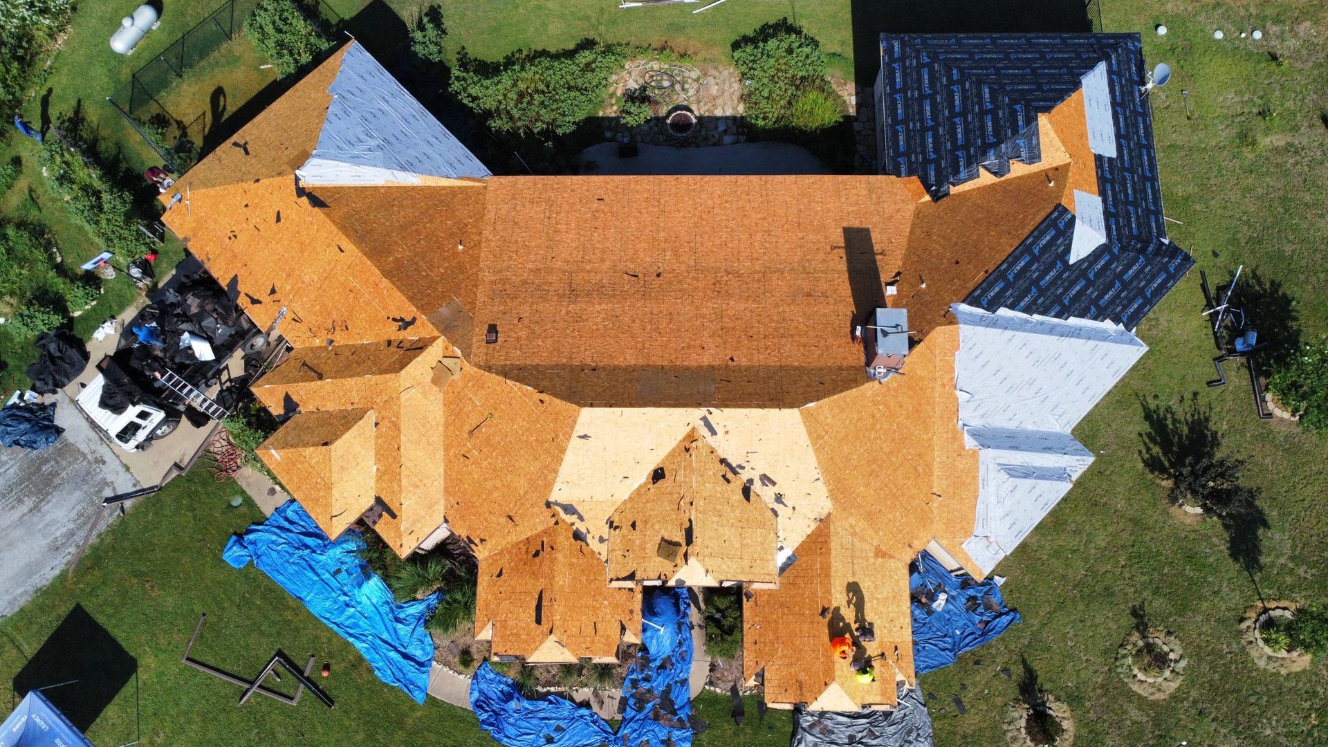 An aerial view of a house with a roof that is being repaired.