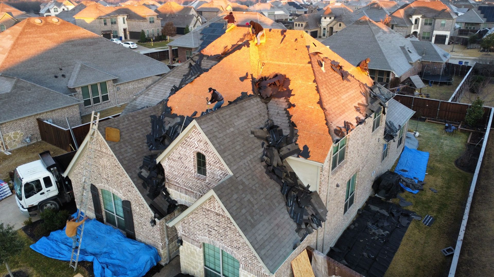 An aerial view of a house with a roof that has been damaged by a fire.