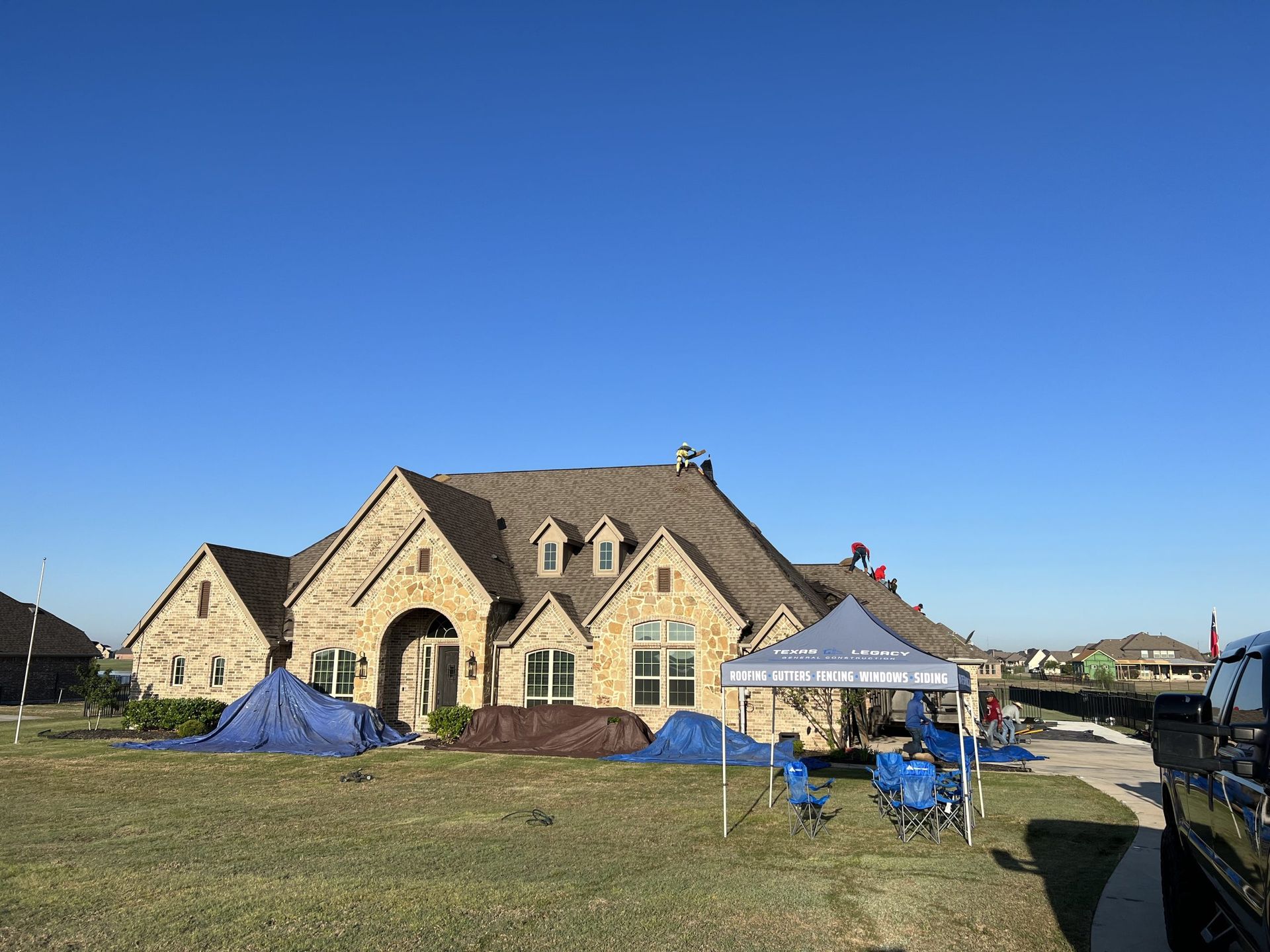 A large house with a blue tent in front of it.