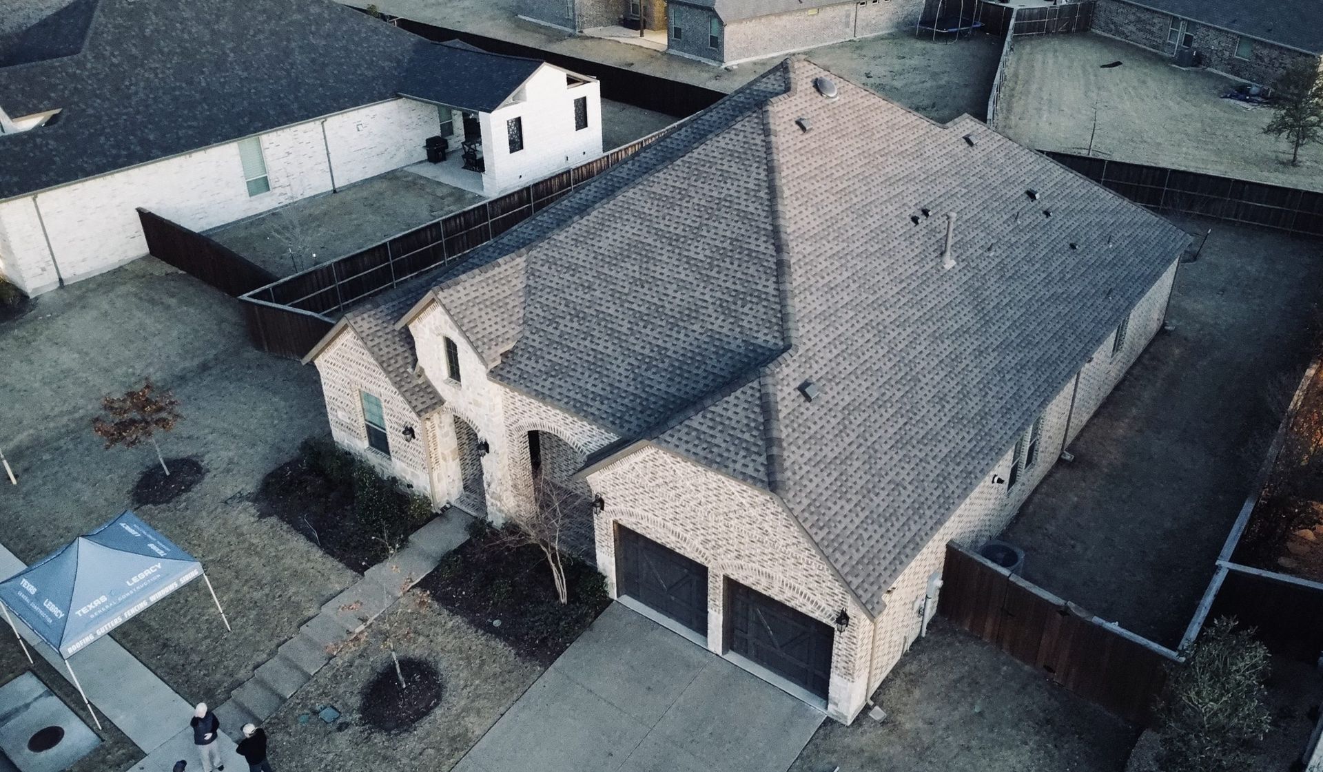 An aerial view of a house with a gray roof