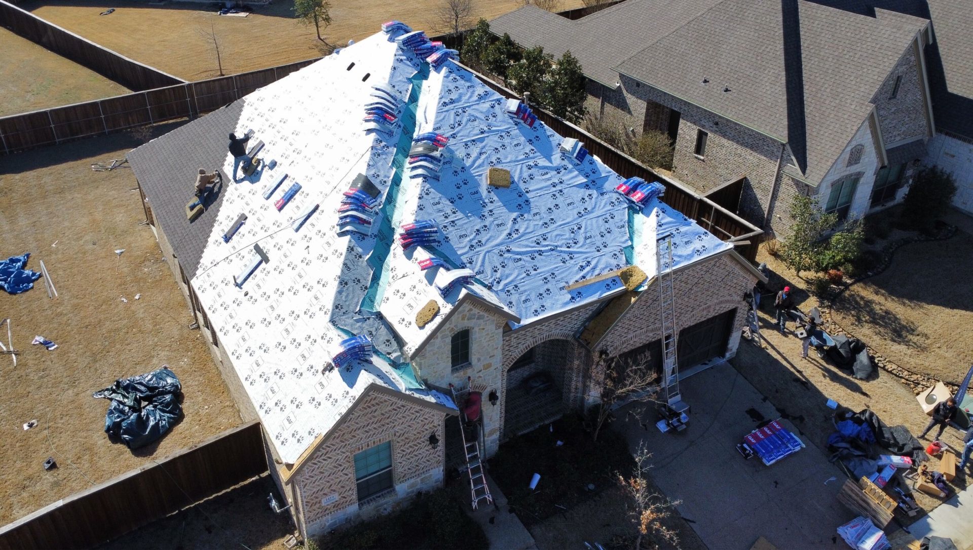 An aerial view of a house with a new roof being installed.