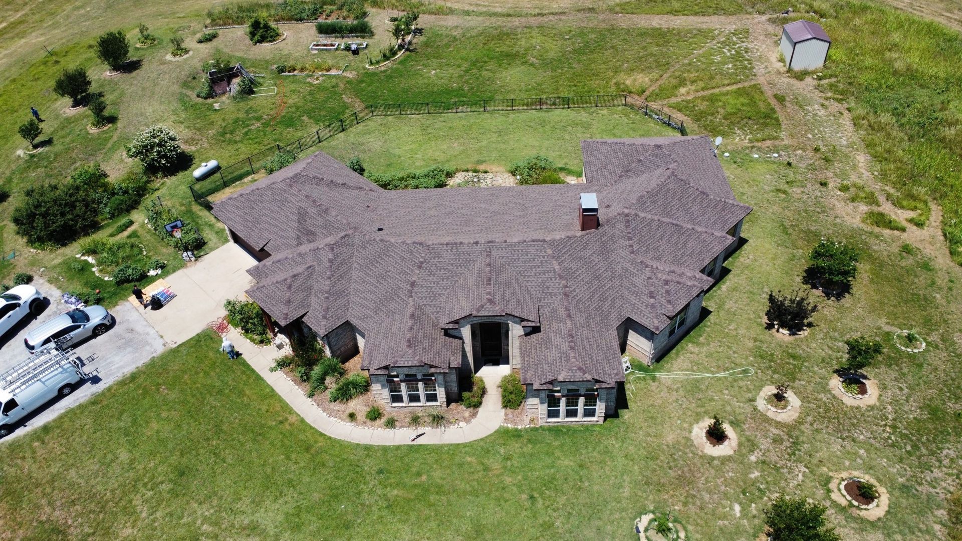 An aerial view of a large house in the middle of a field.