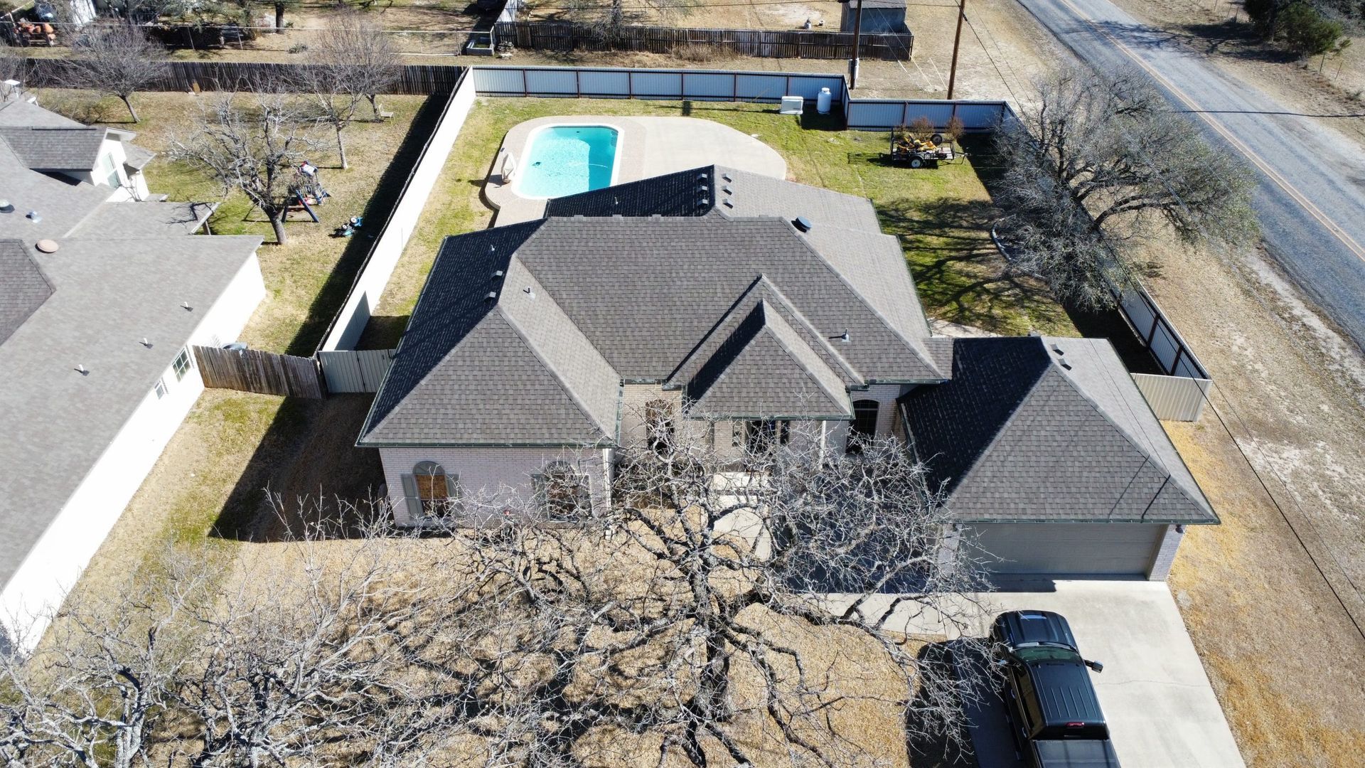 An aerial view of a house with a pool in the backyard