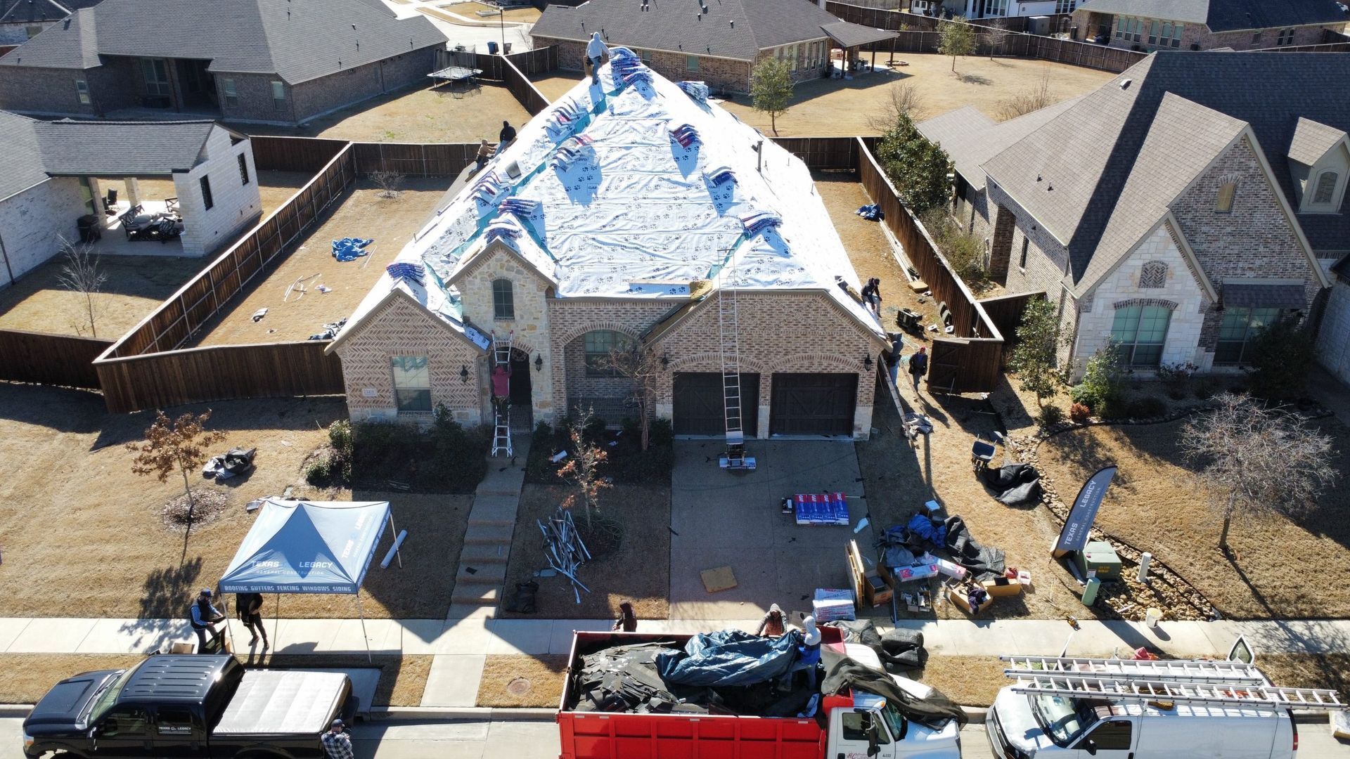 An aerial view of a house under construction in a residential area.