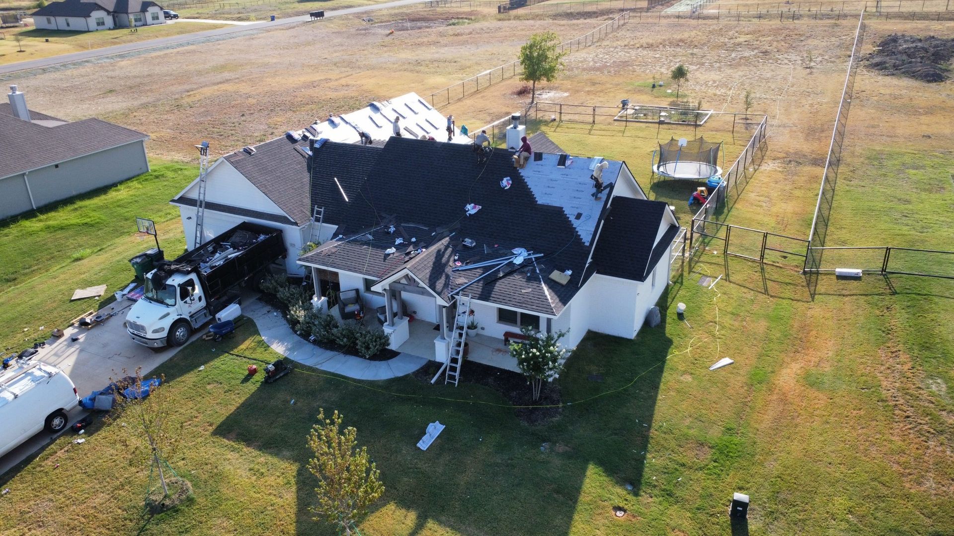 An aerial view of a house being remodeled with a truck parked in front of it.