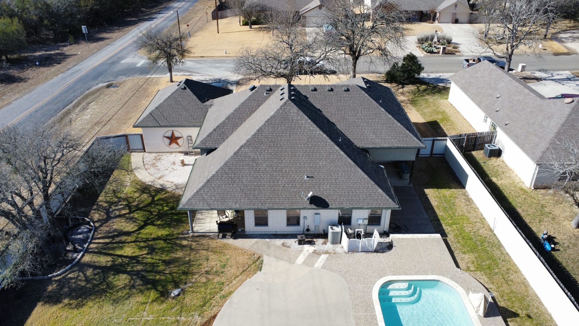 An aerial view of a house with a pool in the backyard