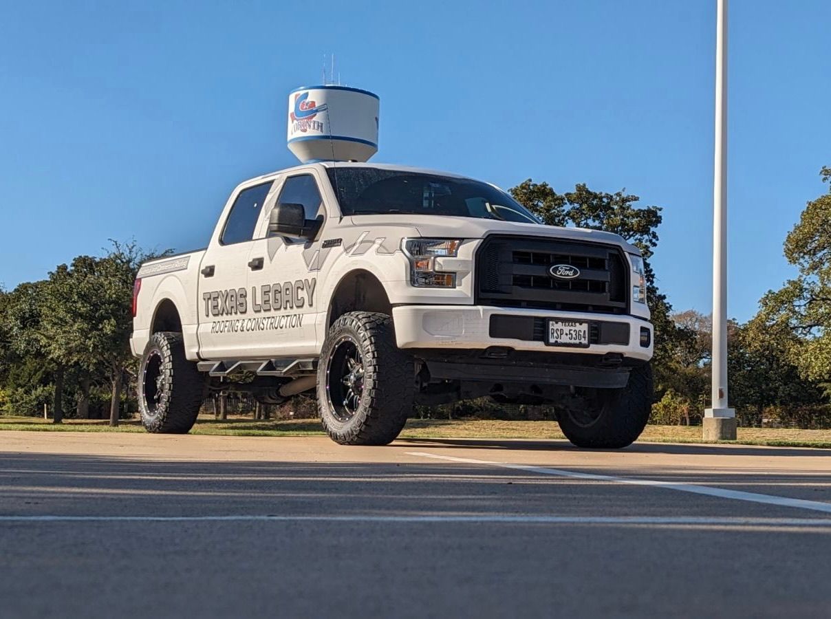 A white truck with a satellite dish on top of it is parked in a parking lot.
