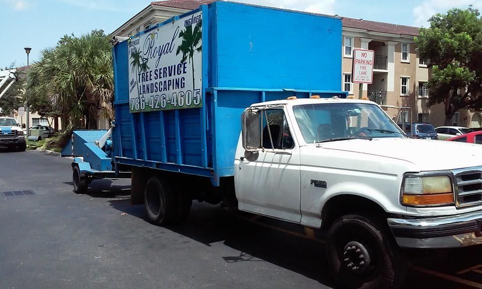 A white truck is parked in a parking lot with a blue box on the back that says
