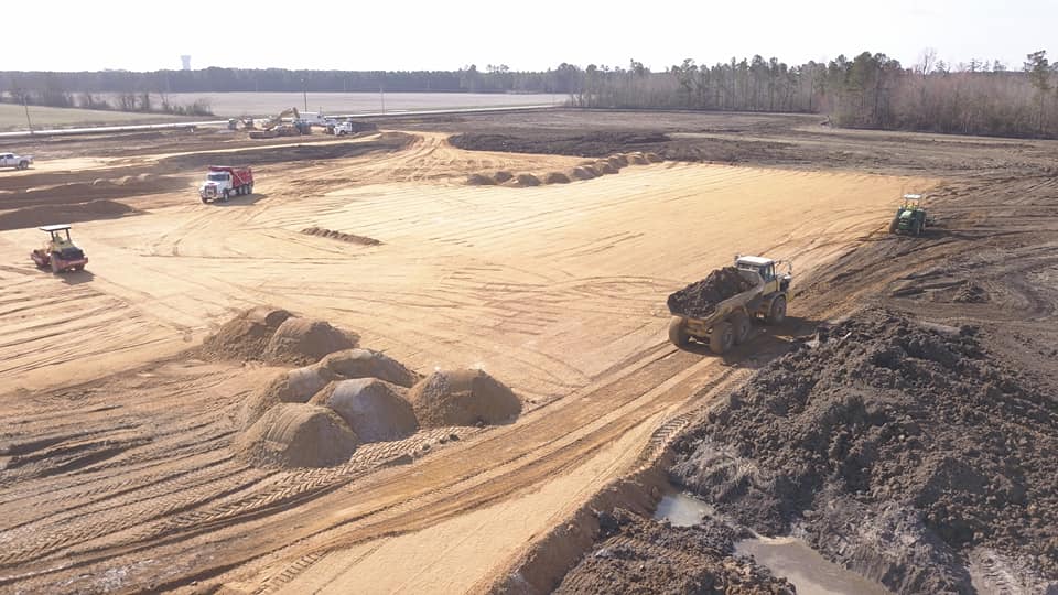 Digger and bulldozer clearing forest land