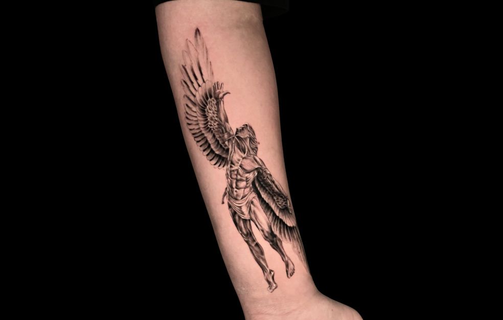 a person has a tattoo of an angel on their forearm .