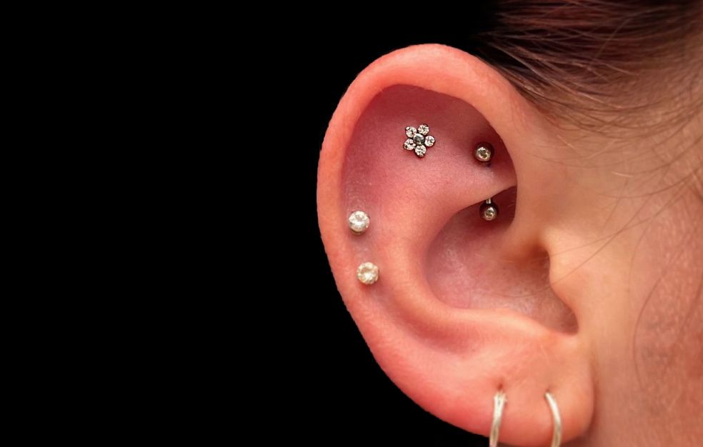 a close up of a woman 's ear with multiple piercings .