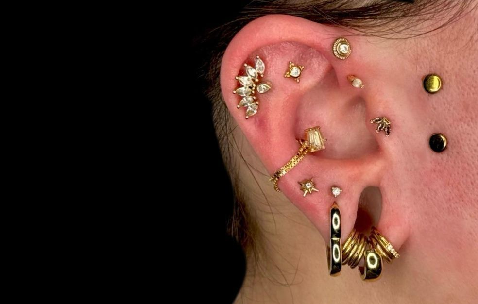 a close up of a woman 's ear with a lot of piercings .