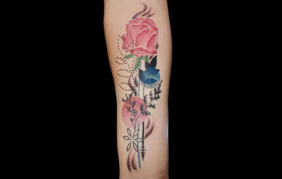 a woman has a tattoo of flowers and a bird on her forearm.