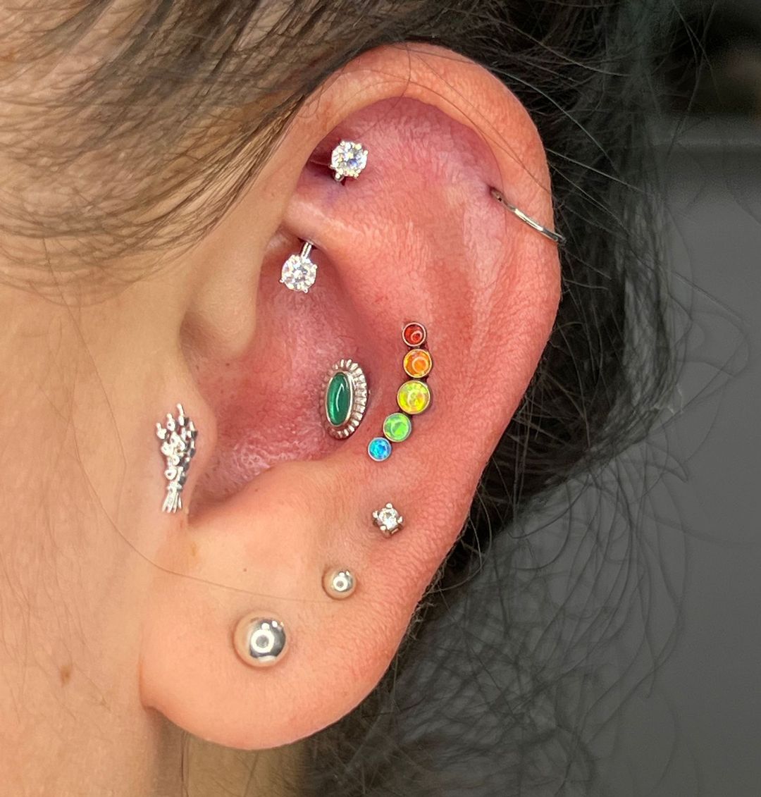 a close up of a woman 's ear with a lot of piercings .