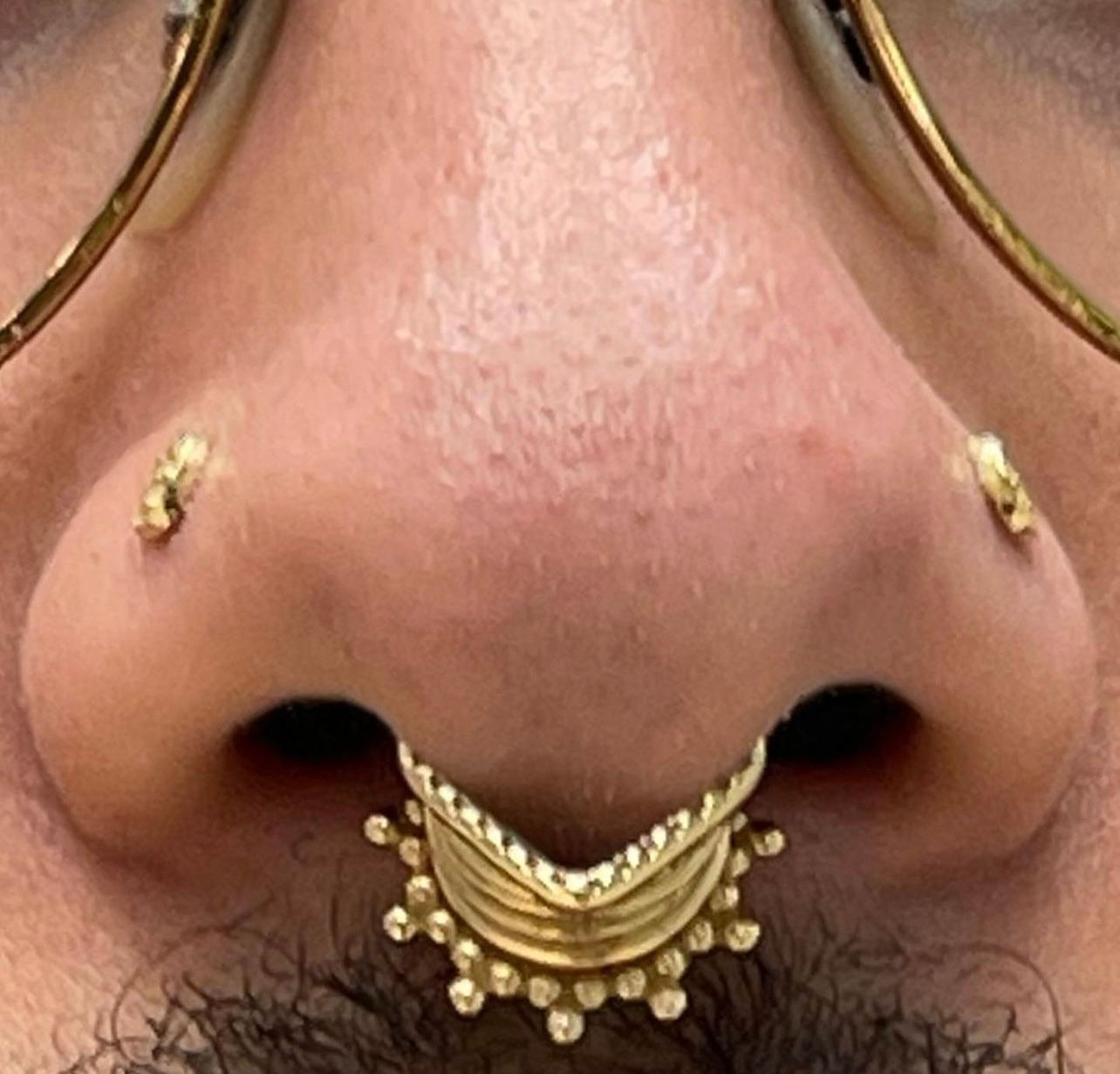 a close up of a person 's nose with a nose ring