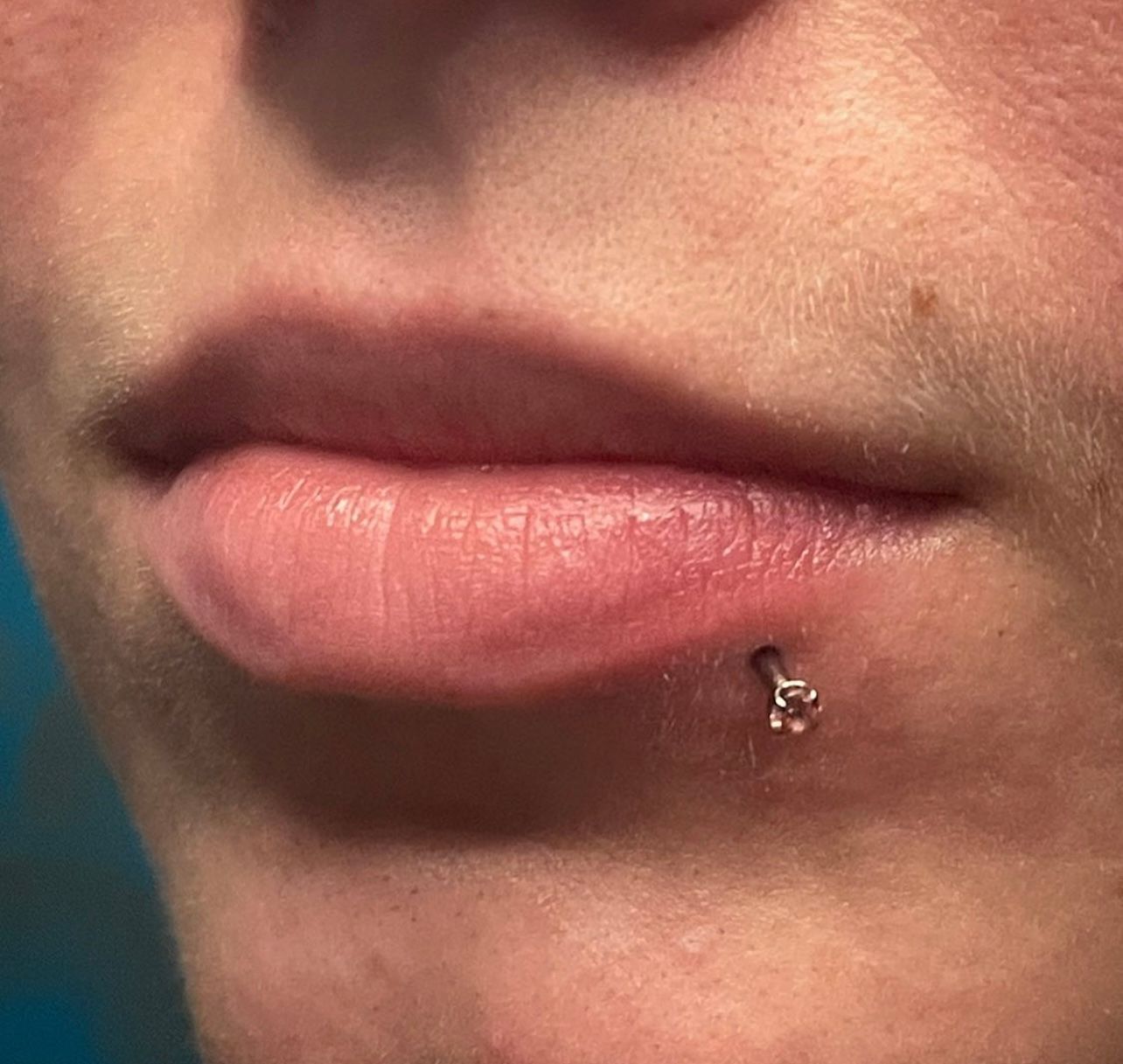 a close up of a woman 's lips with a lip ring .