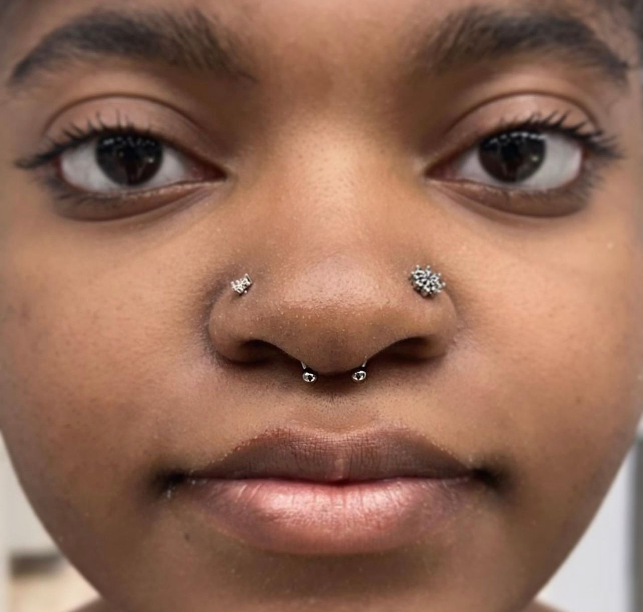 a close up of a woman 's face with a nose ring