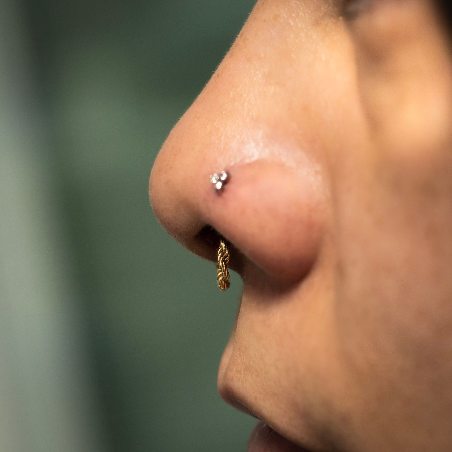 a close up of a woman 's nose with a nose ring .