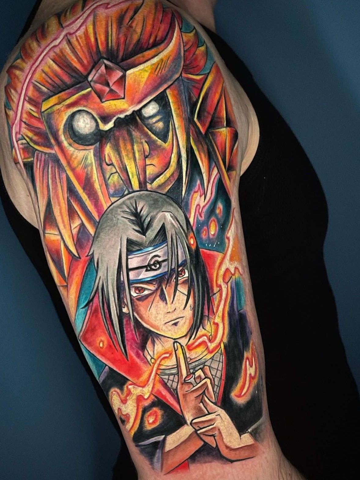 a person has a tattoo of Itachi Uchiha from Naruto on their arm.