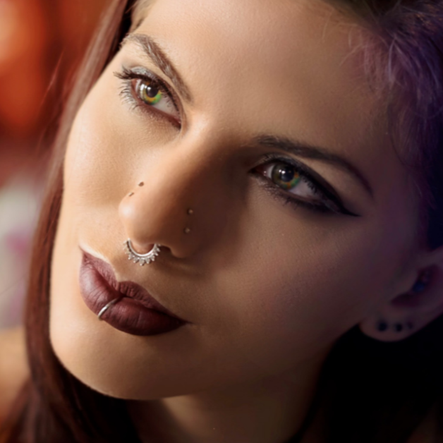 a close up of a woman 's face with a nose ring