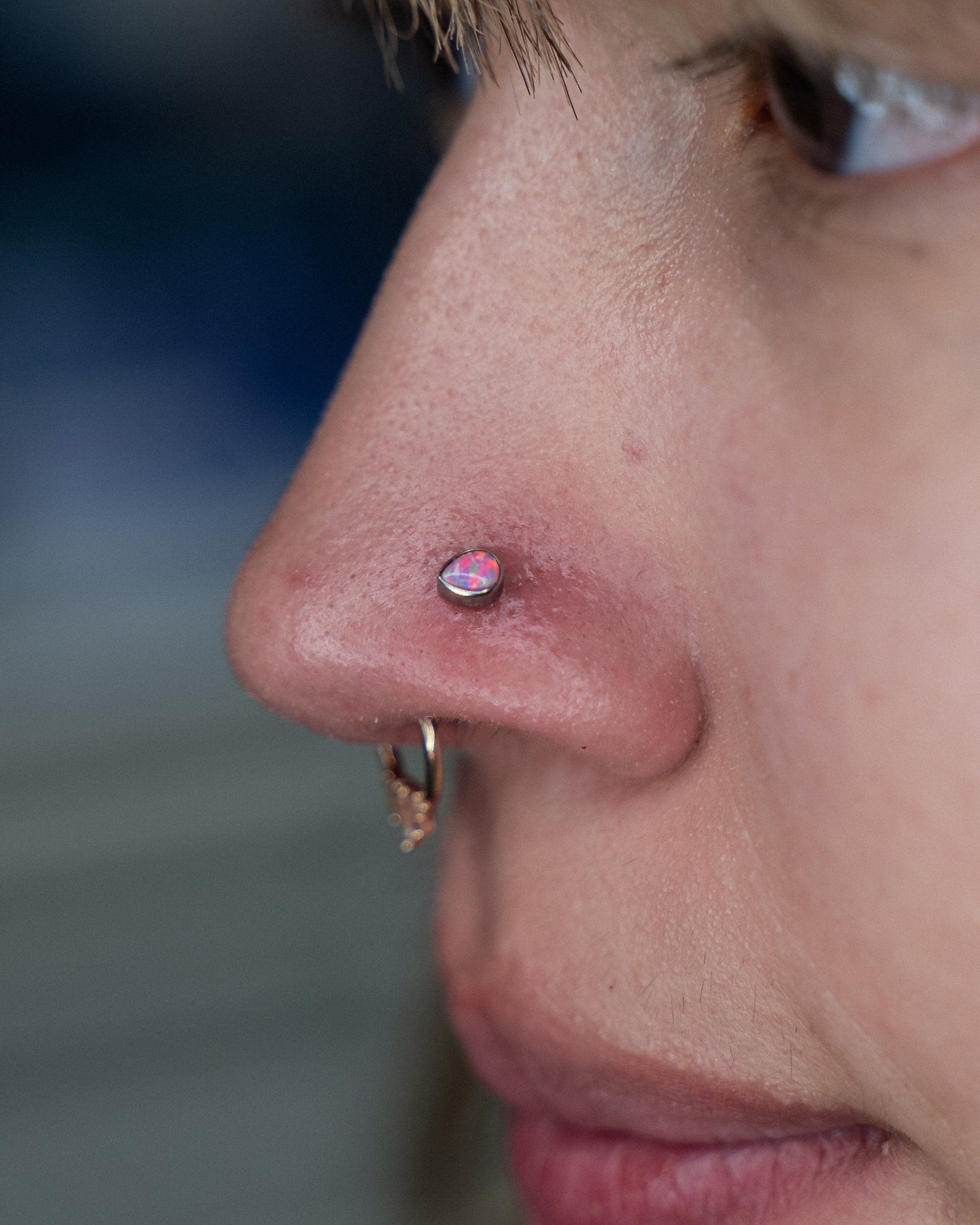 a close up of a woman 's nose with a nose ring .