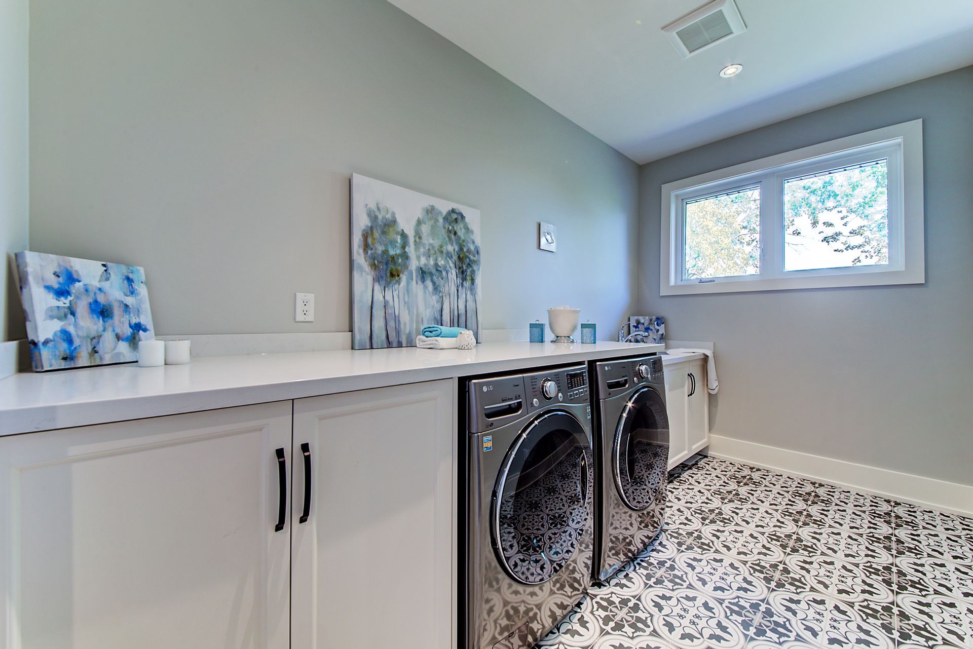 A laundry room with a washer and dryer and a window.