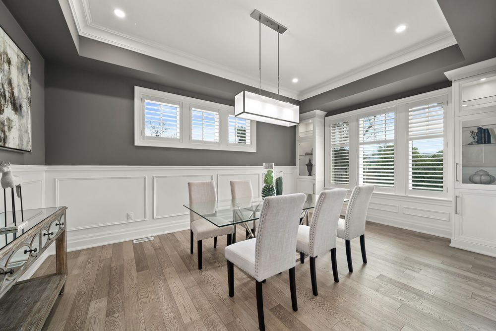 A dining room with a table and chairs and a chandelier on Tansley Drive by Oakroots Construction