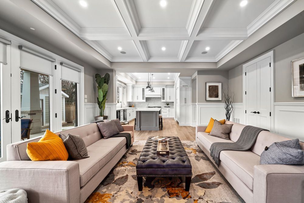A living room with two couches, a coffee table, and a rug on Tansley Drive by Oakroots Construction