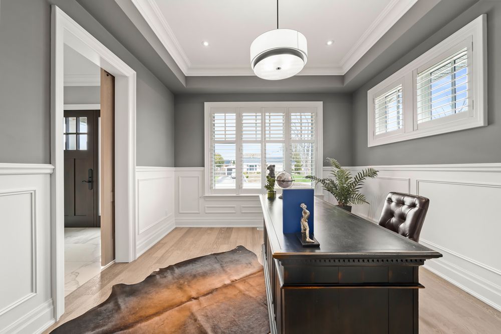 A home office with a desk, chair and rug on Tansley Drive by Oakroots Construction