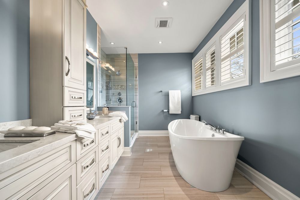 A bathroom with a tub, sink, and shower on Tansley Drive by Oakroots Construction