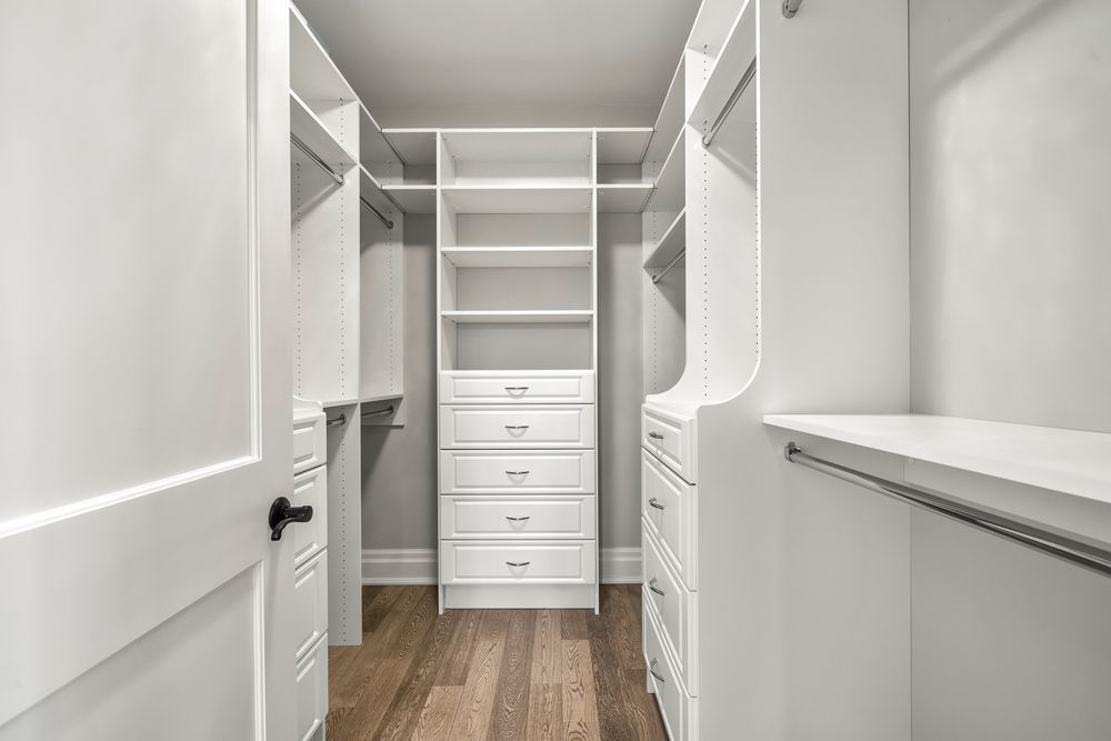 It is a walk-in closet with lots of shelves and drawers on Tansley Drive by Oakroots Construction