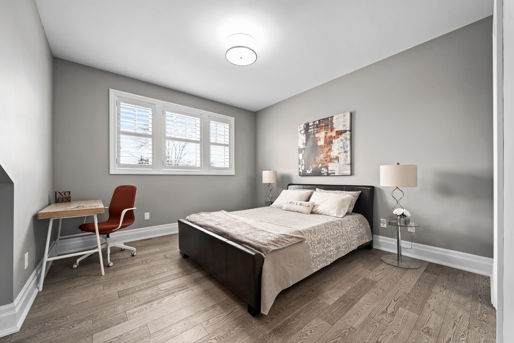A bedroom with a bed, desk and chair on Tansley Drive by Oakroots Construction