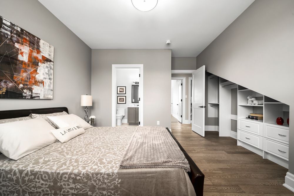 A bedroom with a large bed and a walk-in closet on Tansley Drive by Oakroots Construction