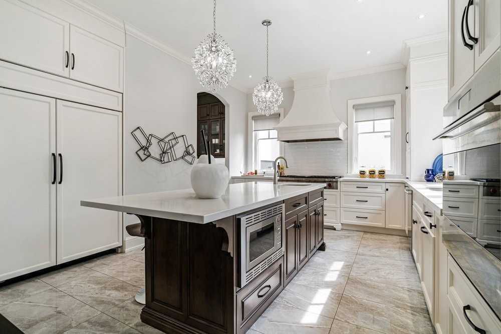 A kitchen with white cabinets and a large island in the middle.