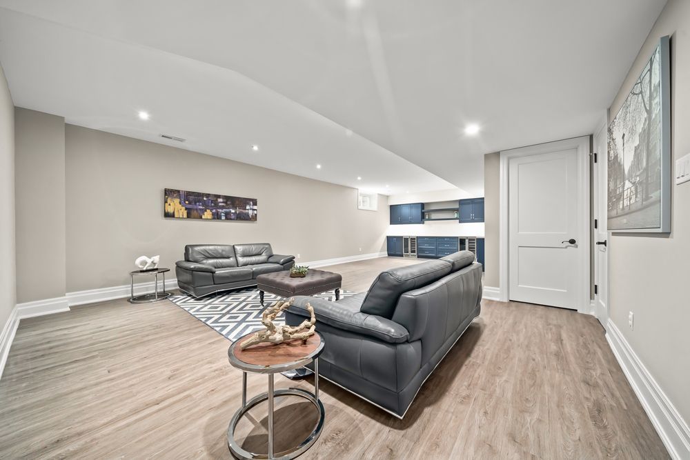 A living room in a basement with a couch and a table on Tansley Drive by Oakroots Construction