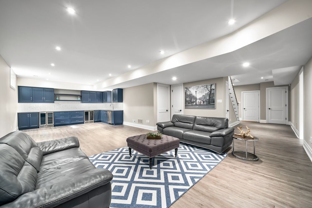 A living room with two couches, a coffee table, and a rug on Tansley Drive by Oakroots Construction