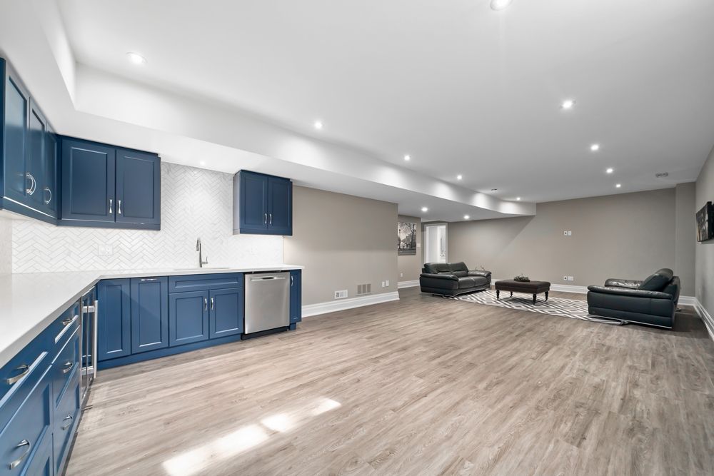 A basement with a kitchen , living room , and couch on Tansley Drive by Oakroots Construction