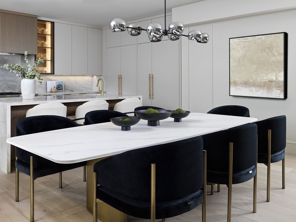 A dining room with a table and chairs and a painting on the wall in Angelene St by Oakroots Construction