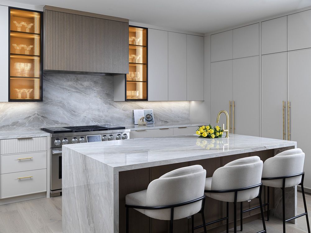 A kitchen with a large island, stools and a stove in Angelene St by Oakroots Construction