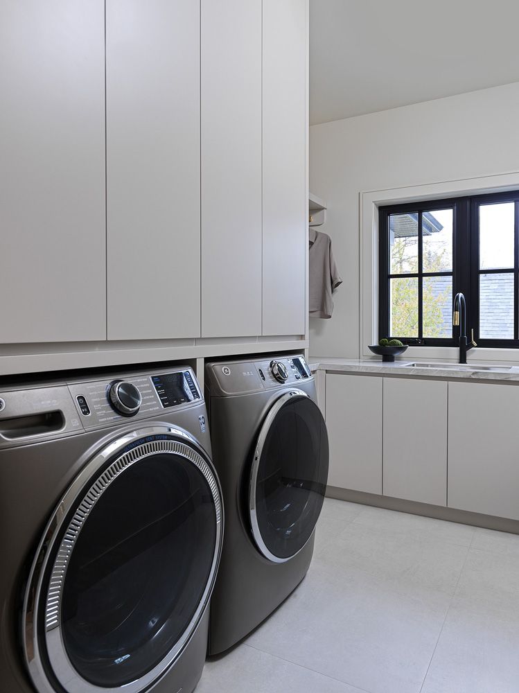A laundry room with a washer and dryer and a window in Angelene St by Oakroots Construction