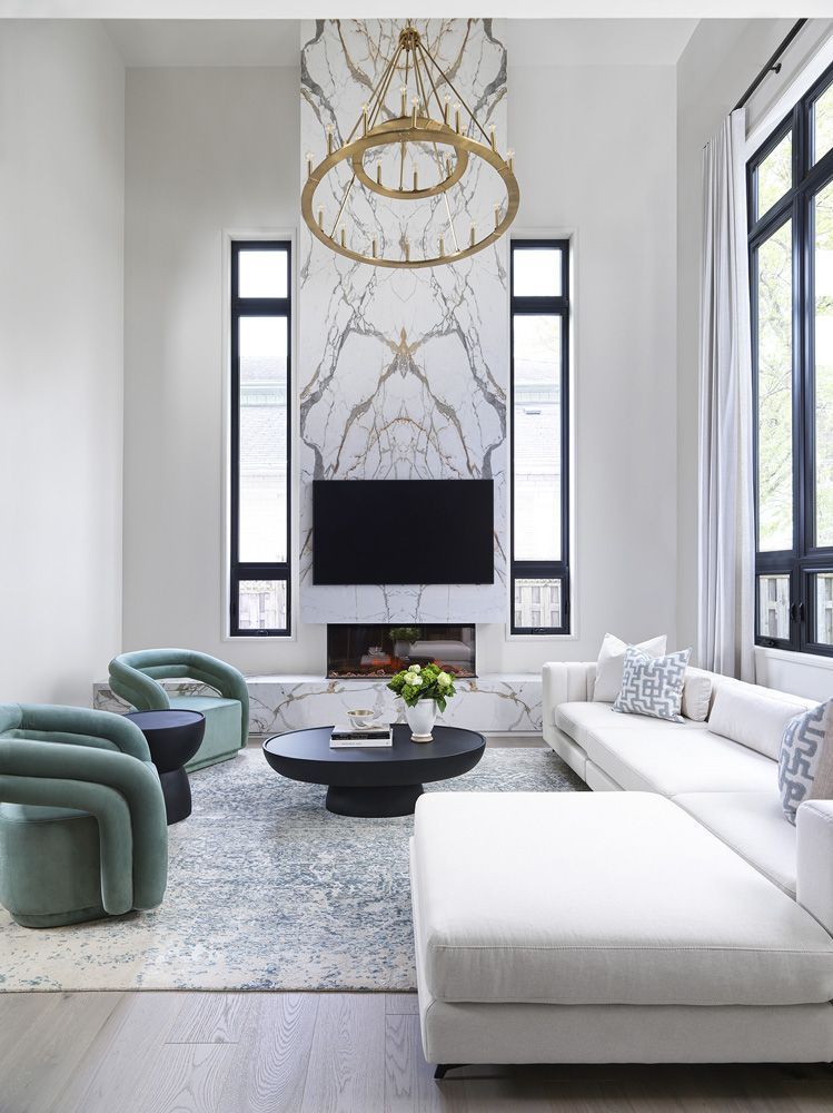 A living room with a couch, chairs , coffee table and television in Angelene St by Oakroots Construction