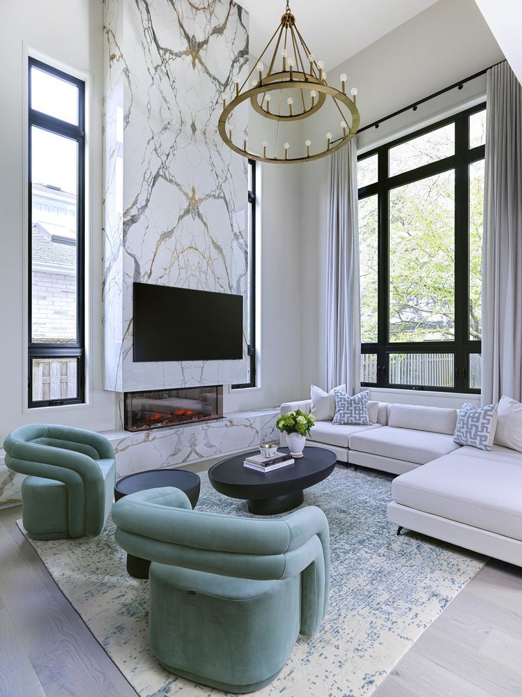 A living room with a couch, chairs, coffee table and television in Angelene St by Oakroots Construction