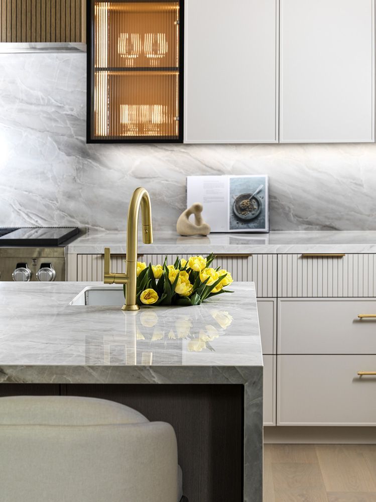 A kitchen with a sink and a vase of flowers on the counter in Angelene St by Oakroots Construction