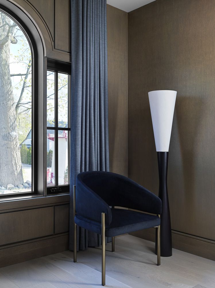 A chair in a room next to a lamp and a window in Angelene St by Oakroots Construction