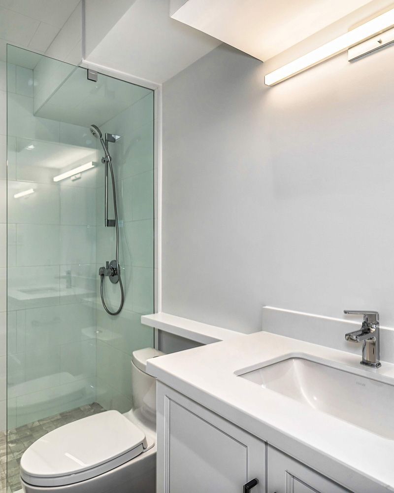 A bathroom with a toilet, sink and shower in Hazelridge Dr by Oakroots Construction