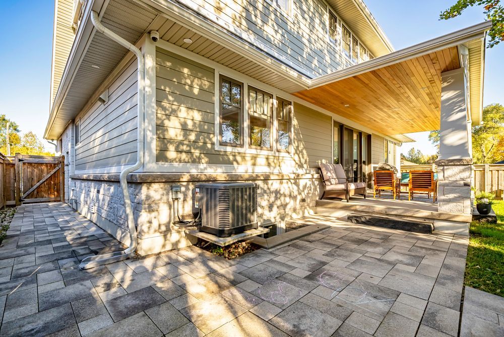 The backyard of a house with a patio and a covered porch on Tansley Drive by Oakroots Construction