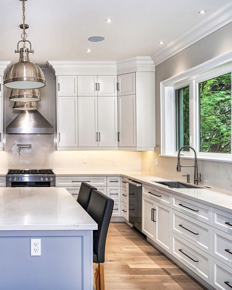 A kitchen with white cabinets and stainless steel appliances in Hazelridge Dr by Oakroots Construction
